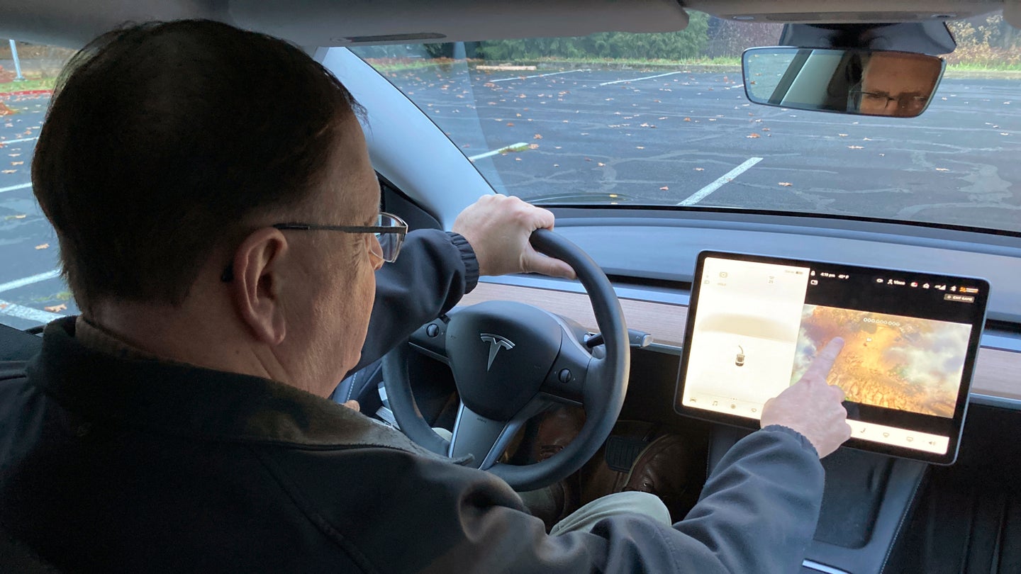 Vince Patton, a new Tesla owner, demonstrates on Dec. 8, 2021 on a closed course in Portland, Ore. how he can play video games on the vehicle’s console while driving. Powell, of Portland, Oregon, filed a complaint with federal regulators after discovering the feature in his new car. (AP Photo/Gillian Flaccus)