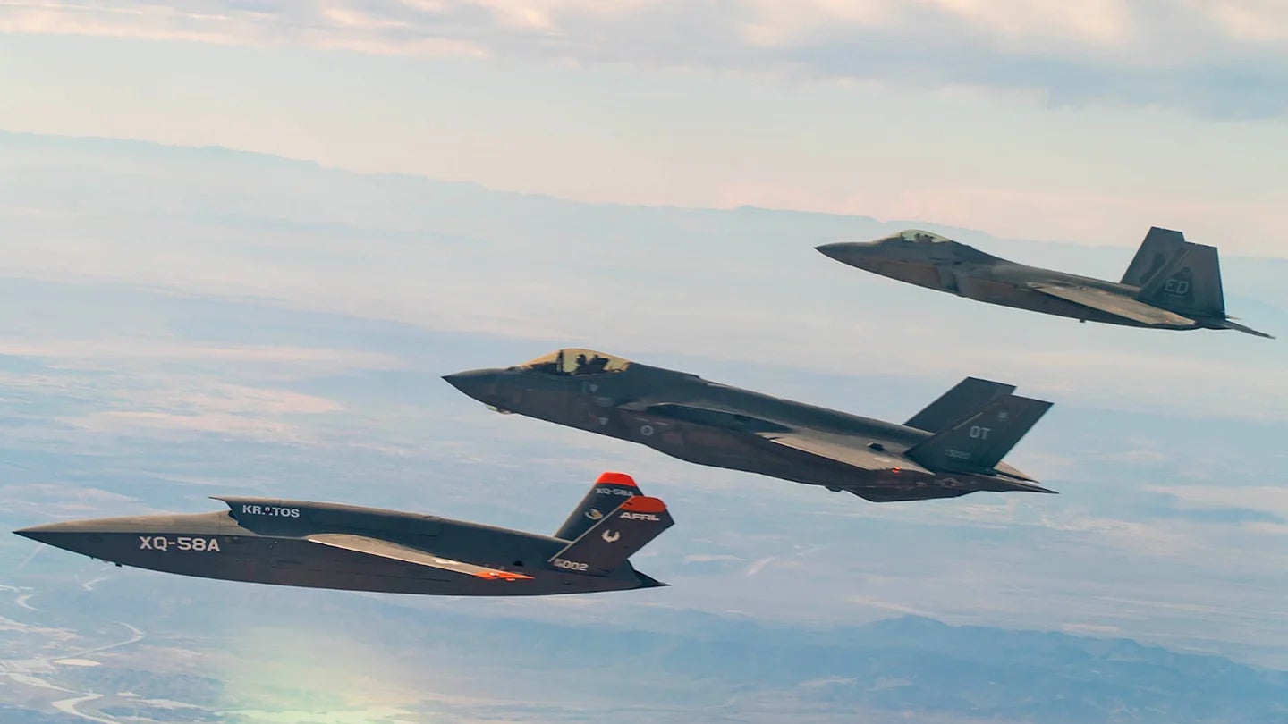 One of the Air Force's XQ-58A Valkyrie drones, at left, flies together with an F-35A Joint Strike Fighter, at center, and an F-22 Raptor stealth fighter, at right, during a test.