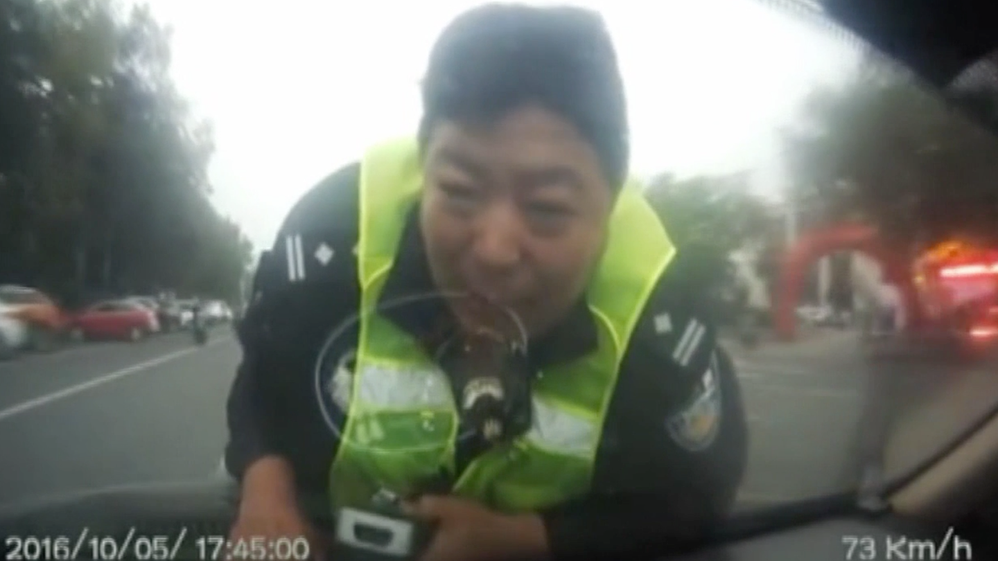 Watch This Cop Cling to a Car’s Hood at 60 MPH