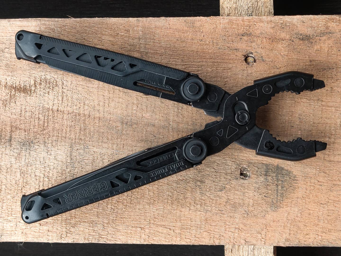 Gerber's Dual-Force multitool laying on a wood pallet