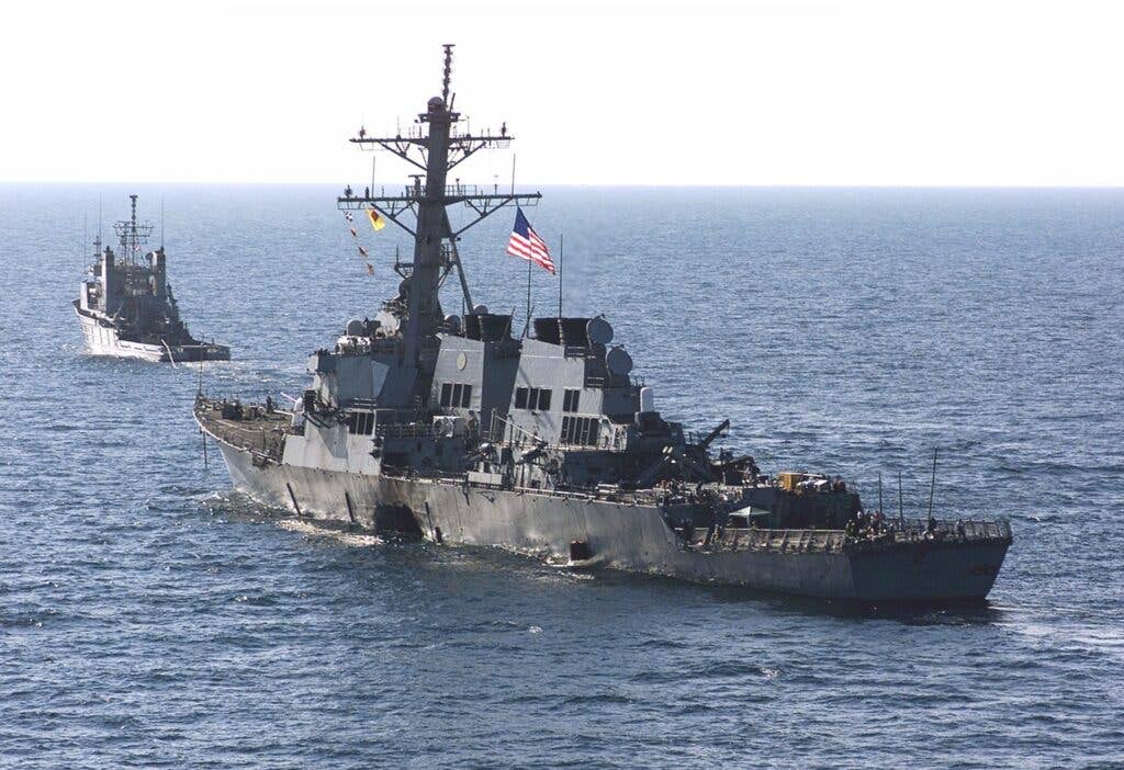 The USS&nbsp;<em>Cole</em> is towed away from the port city of Aden, Yemen, into open waters by the Military Sealift Command ocean-going tug USNS&nbsp;<em>Catawba</em>&nbsp;on October 29, 2000. The&nbsp;<em>Cole</em>&nbsp;was then placed aboard the civilian heavy transport ship<em> Blue Marlin</em>&nbsp;and transported back to the United States for repair. <em>U.S. Navy</em>
