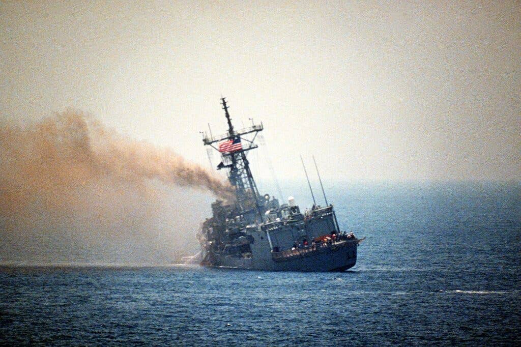 In the Persian Gulf, the USS <em>Stark</em> lists to port after being hit by two Iraqi Exocet missiles within a space of 30 seconds, in May 1987. <em>U.S. Navy</em><br>