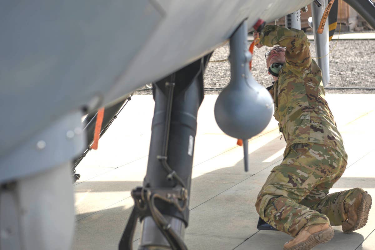 A U.S. Air Force remotely piloted aircraft pilot assigned to the 12th Expeditionary Special Operations Squadron performs a pre-flight inspection on an MQ-9 unmanned aviation aircraft at Chabelley Airfield, Djibouti, on March 19, 2021. <em>U.S. Air Force photo by Staff Sgt. Matthew J. Wisher</em>