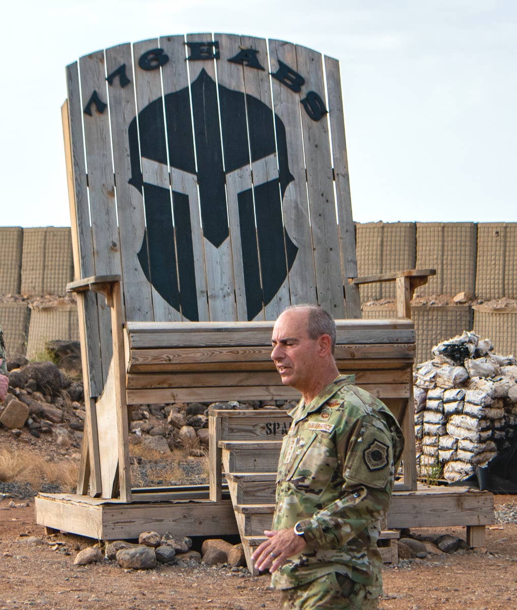 An oversized wooden chair at Chabelley Airfield belonging to the 776th Expeditionary Air Base Squadron (EABS) with a Spartan helmet motif.