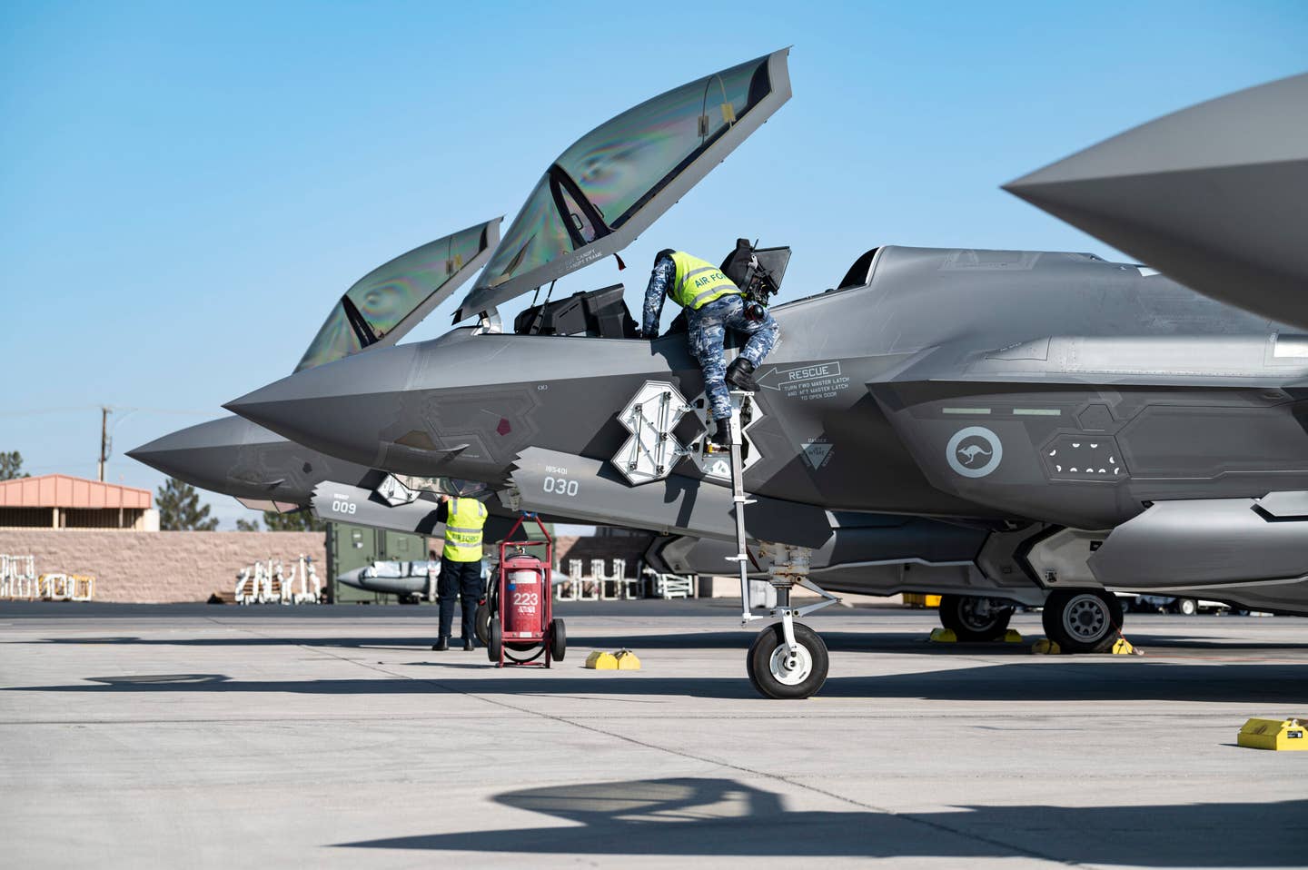 Maintenance crews from the Royal Australian Air Force prepare two F-35As for a training mission at Nellis Air Force Base, Nevada, in April. <em>U.S. Air Force photo by William R. Lewis</em>