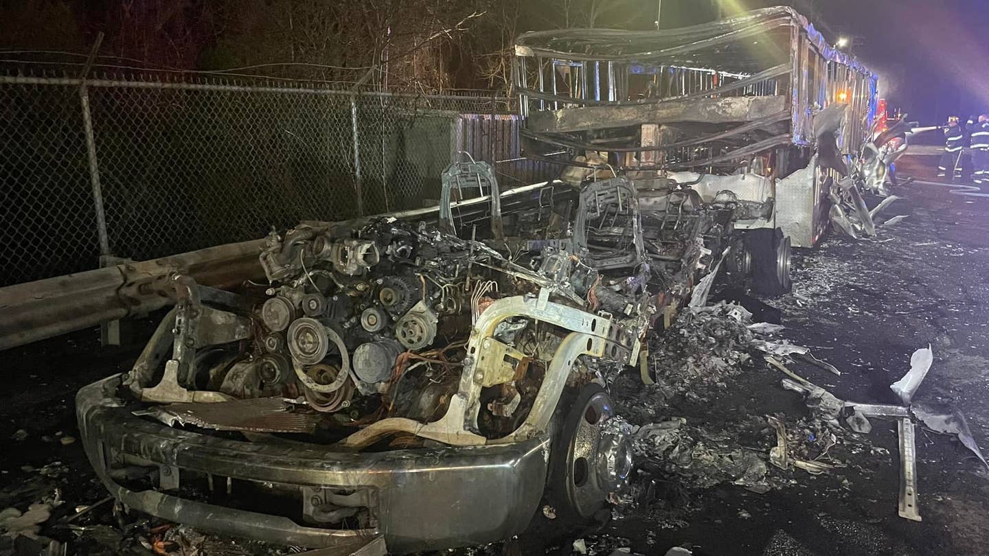 A semi truck and its car carrier trailer burned to a husk. Only the remains of the engine and frame of the truck and trailer remain.