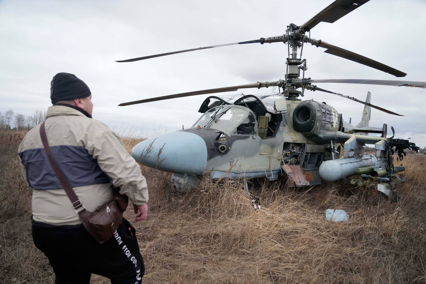 A man stands in front of a Ka-52 attack helicopter forced to land in a field outside Kyiv, Ukraine, on February 24, 2022.&nbsp;<em>AP Photo/Efrem Lukatsky</em>