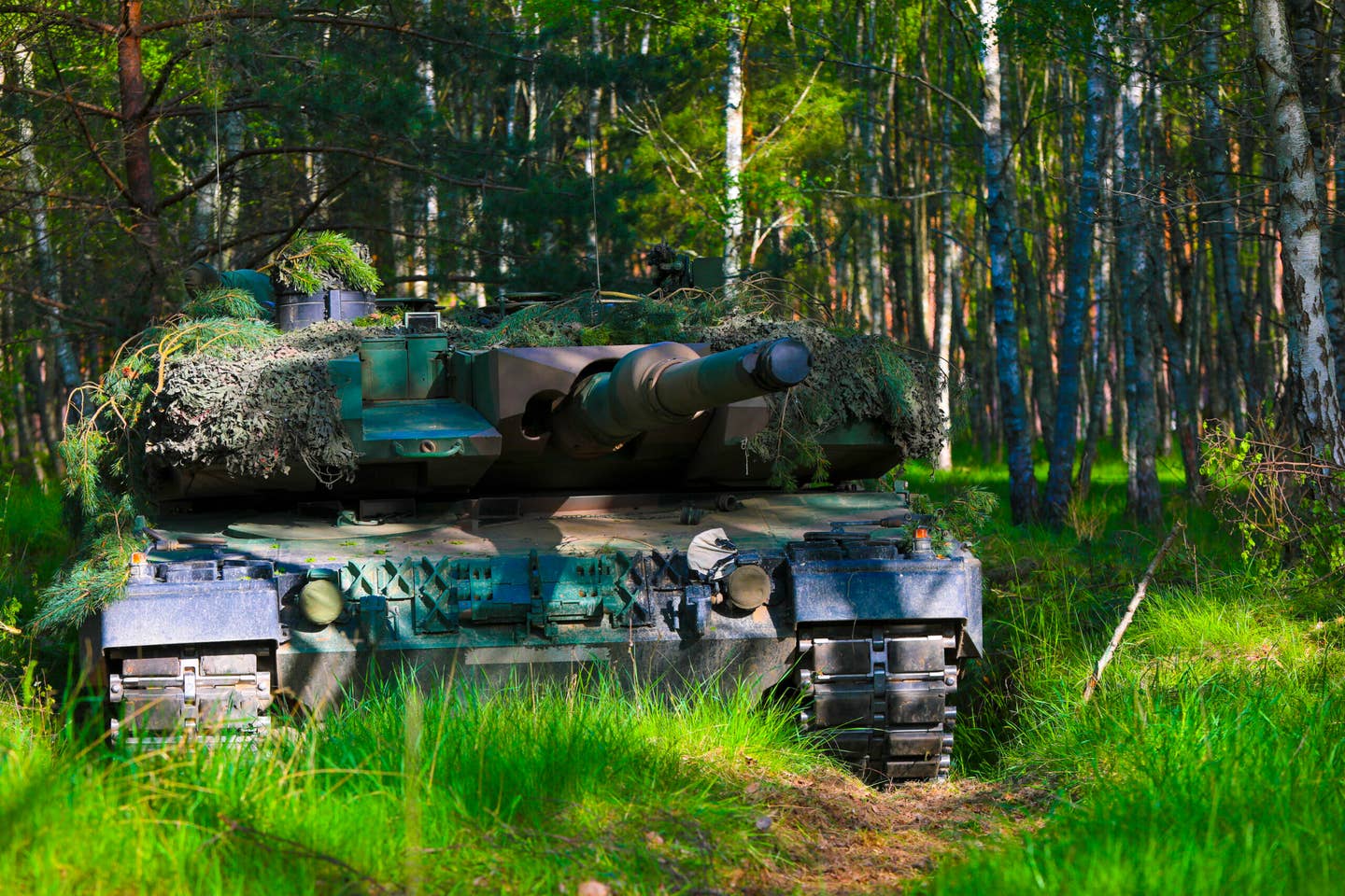 A Polish Leopard tank pulls security during their multinational field training exercise as part of Defender Europe 2022, Drawsko Pomorskie, Poland, May 15, 2022. <em>U.S. Army photo by Sgt. Andrew Greenwood</em>