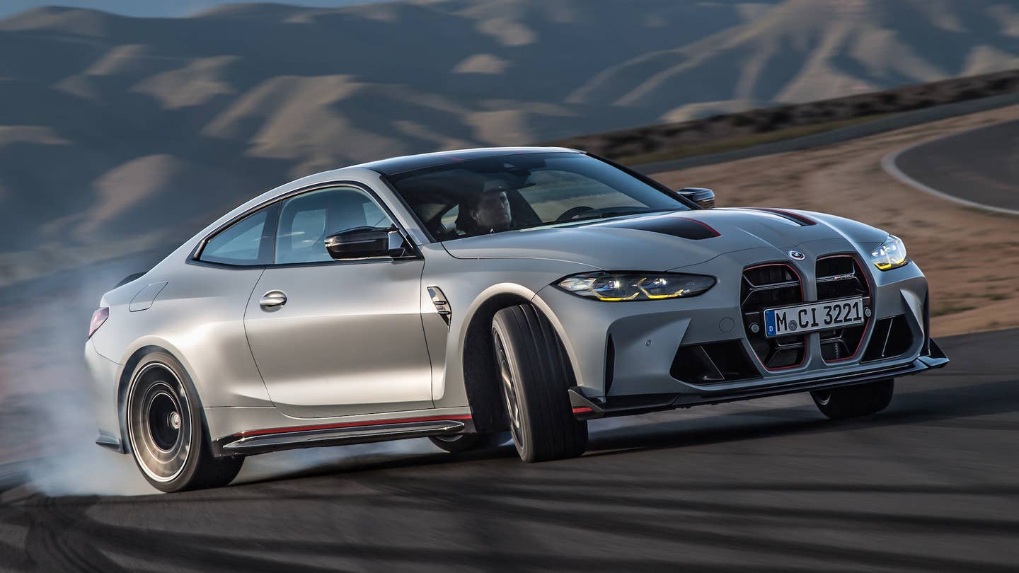 A gray 2023 BMW M4 CSL is powersliding on a racetrack.