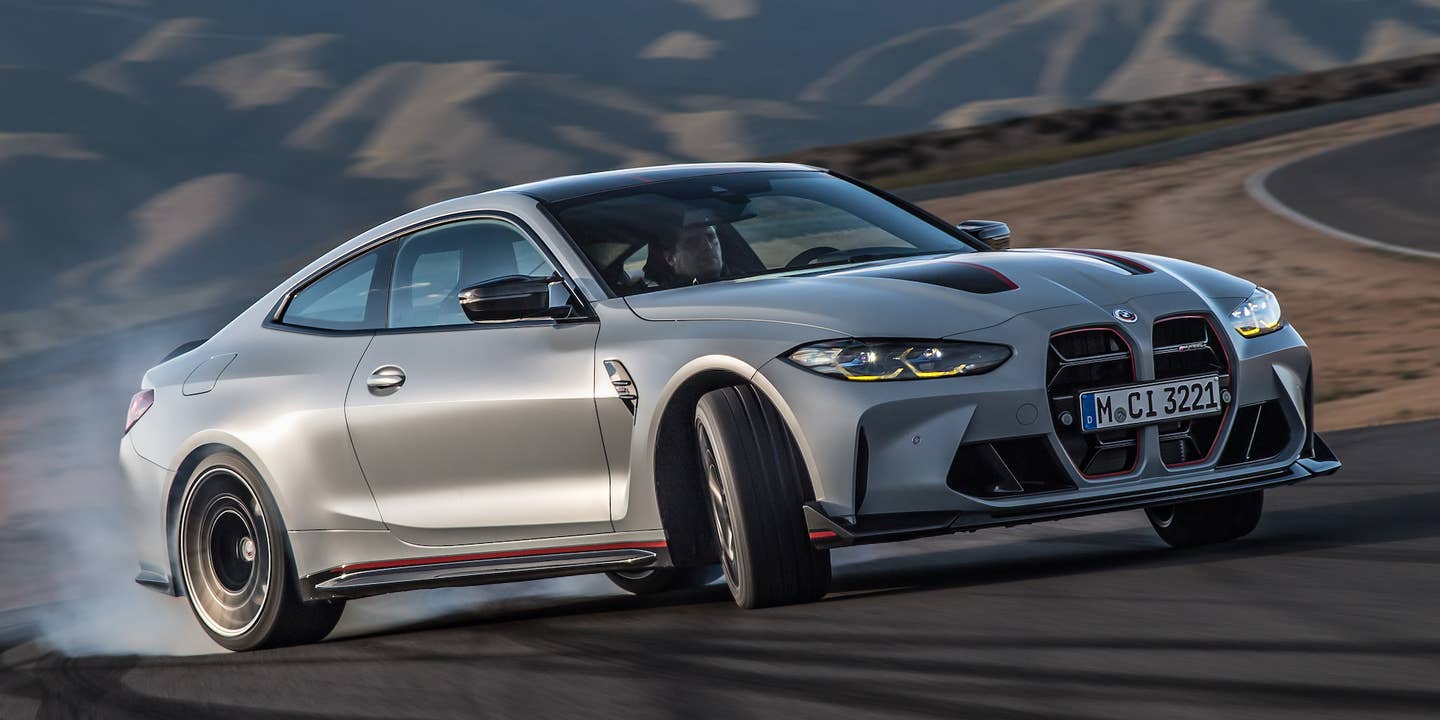 A gray 2023 BMW M4 CSL is powersliding on a racetrack.