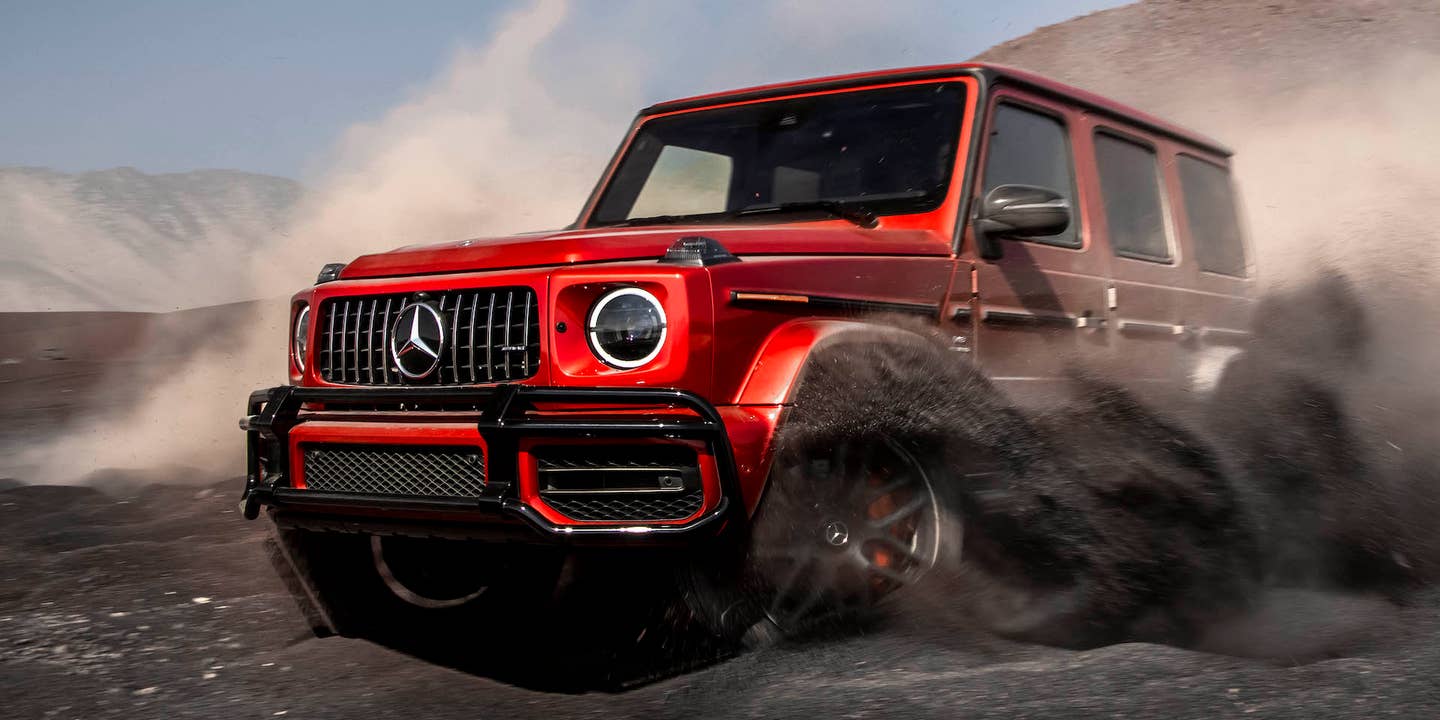 A red Mercedes-AMG G63 throws up clouds of dirt