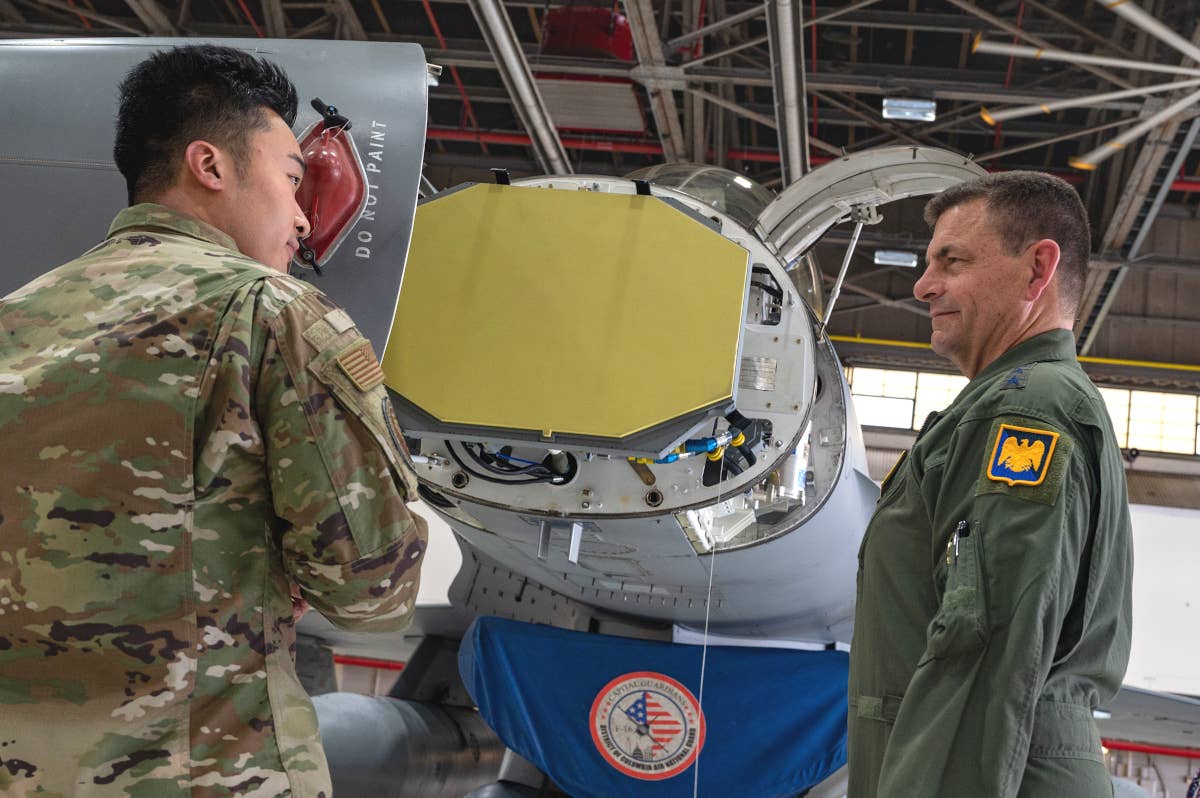 Air Force Lt. Gen. Michael Loh, the Director of the Air National Guard, at right, listens to details about the AN/APG-83 radar, as seen here install in an F-16. This picture was taken at a ceremony on June 9 to mark the completion of an upgrade program to add these radars to 72 Air National Guard jets. <em>Northrop Grumman</em>