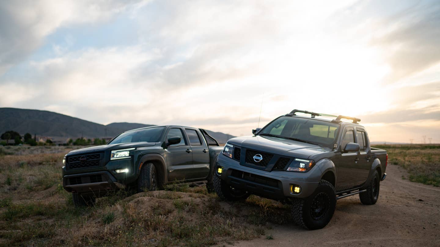 Two Nissan Frontiers parked on a mound. They are parked in a way to show off suspension articulation.
