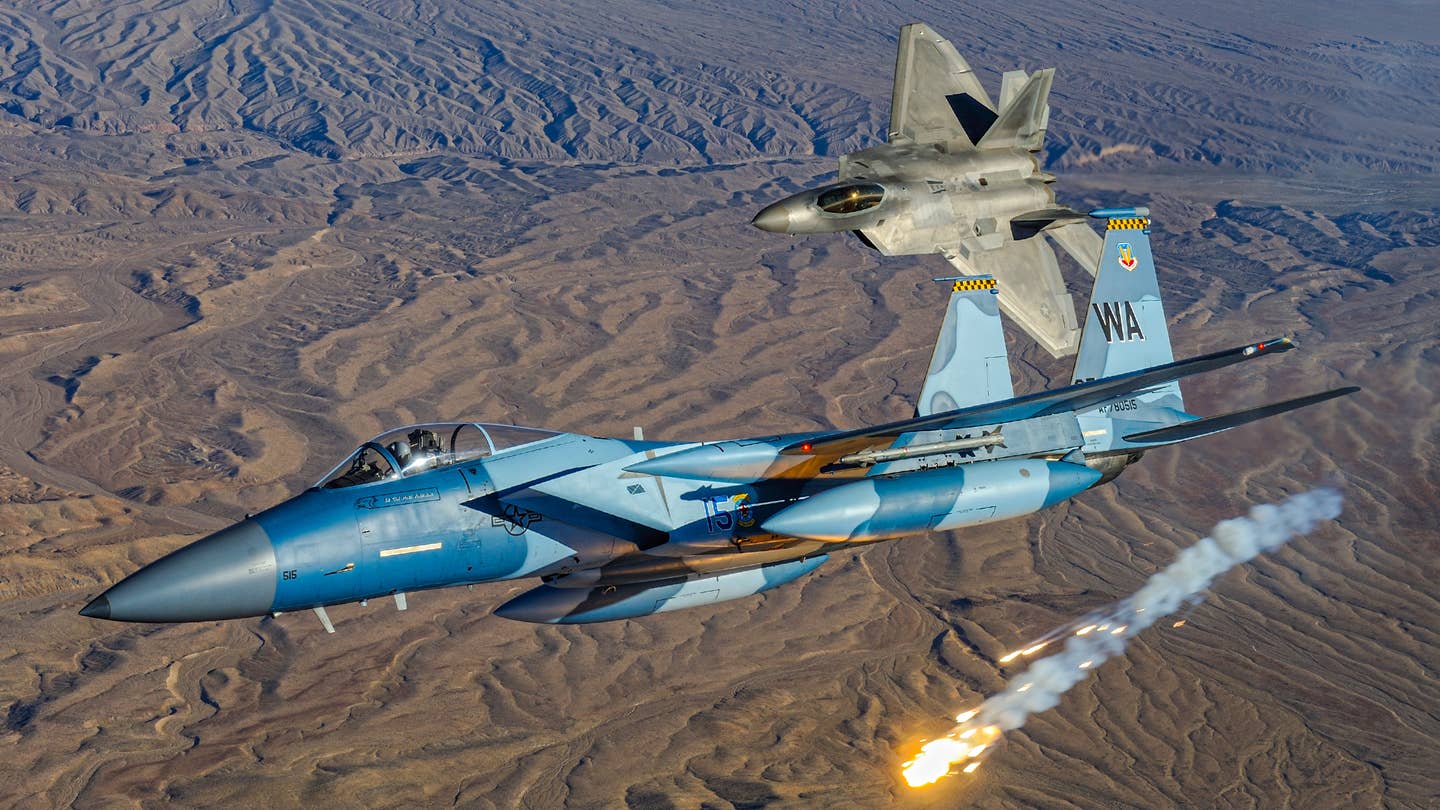 A 65th Aggressor Squadron F-15C is chased by an F-22 Raptor in 2010. <em>Jamie Hunter</em>