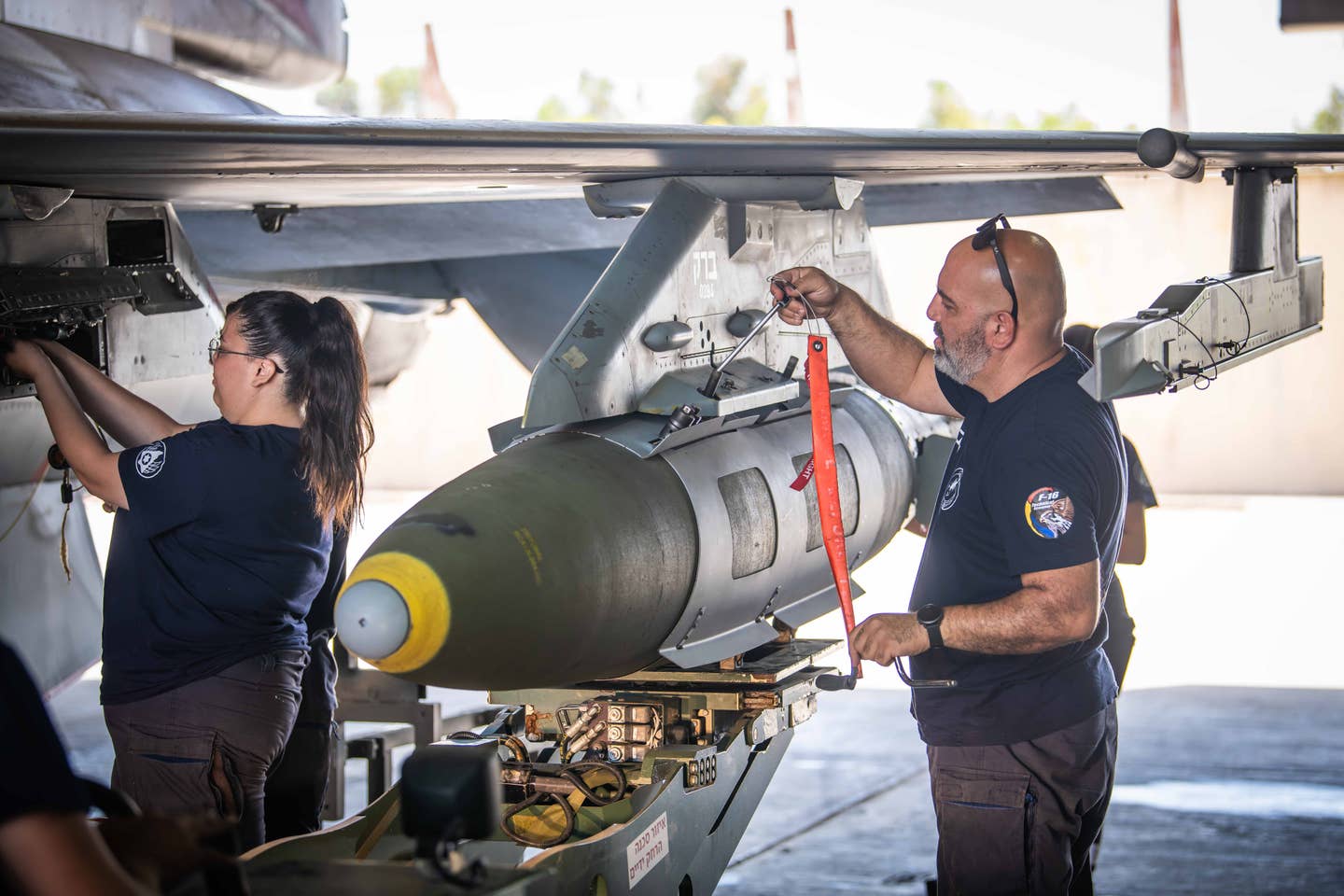 Israeli Air Force armorers load a Joint Direct Attack Munition on an F-16 fighter jet. <em>Israeli Air Force</em>