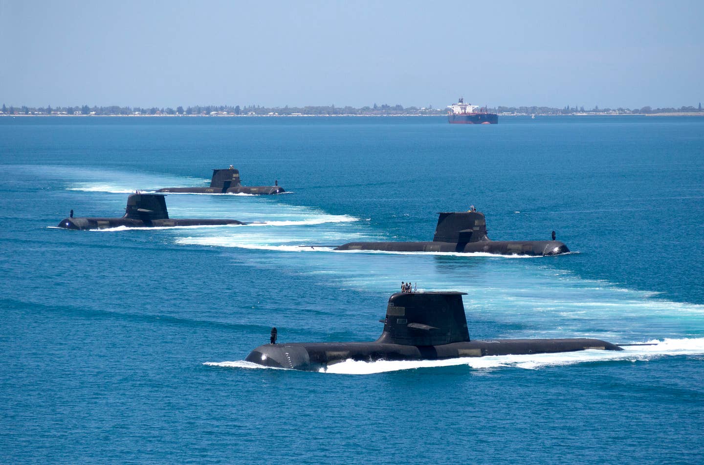 <em>Collins</em> class submarines HMAS <em>Collins</em>, HMAS <em>Farncomb</em>, HMAS <em>Dechaineux</em>, and HMAS <em>Sheean</em> in formation while transiting through Cockburn Sound, Western Australia, in February 2019. <em>Australian Department of Defense</em>