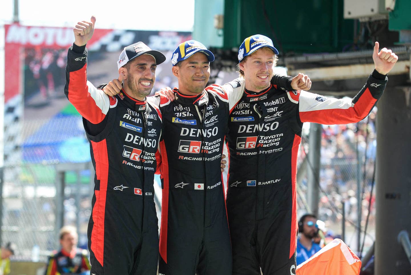 (From L) Drivers of the Toyota number 8 GR010 Hybrid Hypercar Swiss Sebastien Buemi, Japanese Ryo Hirakawa and New Zealand Brendon Hartley celebrate after winning at the end of the 90th edition of the Le Mans 24 Hours endurance race, in Le Mans, north-western France, on June 12, 2022. (Photo by JEAN-FRANCOIS MONIER / AFP) (Photo by JEAN-FRANCOIS MONIER/AFP via Getty Images)
