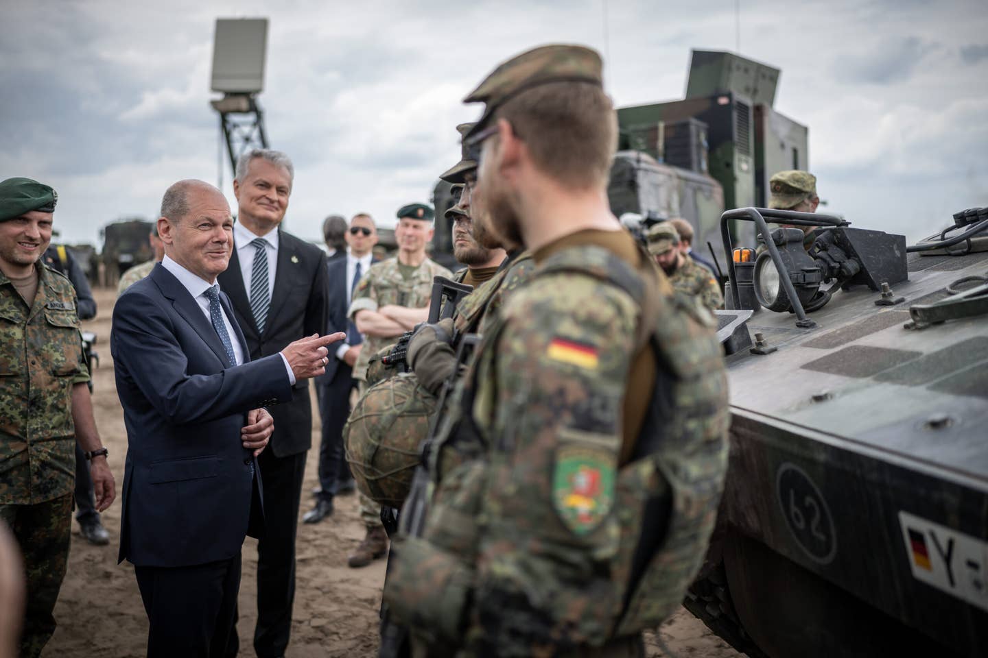 German Chancellor Olaf Scholz speaks with soldiers alongside Gitanas Nauseda, President of Lithuania (third from left), at Camp Adrian Rohn, Lithuania, where more than 1,000 German soldiers are currently stationed as part of the NATO Enhanced Forward Presence Battle Group. <em>Photo by Michael Kappeler/picture alliance via Getty Images</em>