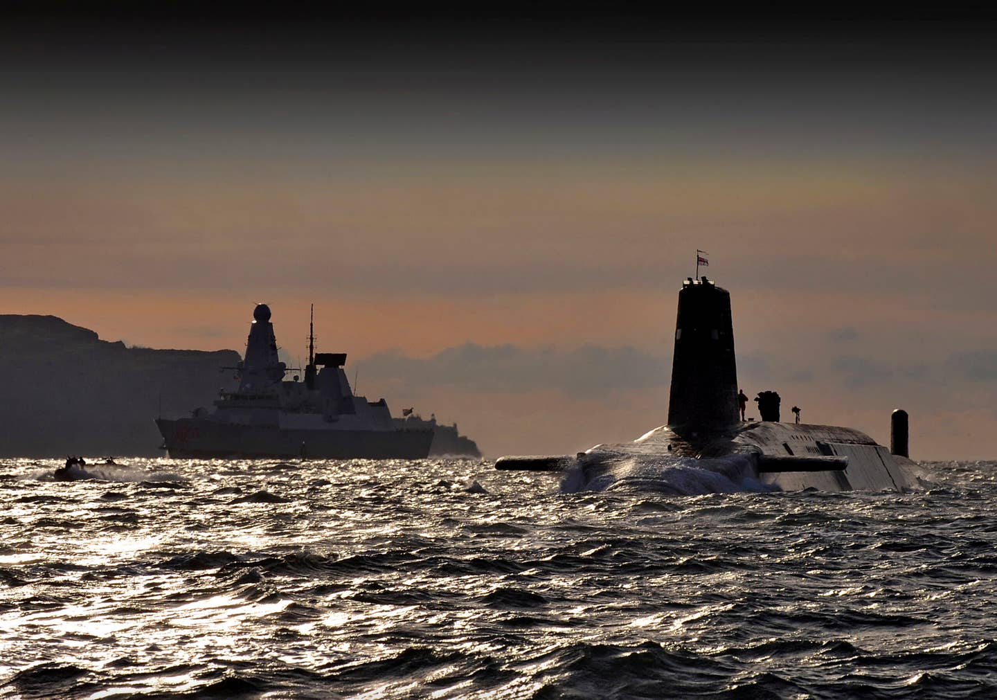 HMS <em>Vanguard</em> arrives back at HMNB Clyde, Faslane, Scotland following a patrol. The Type 45 destroyer HMS <em>Dragon</em> can be seen in the background. <em>Crown Copyright</em>