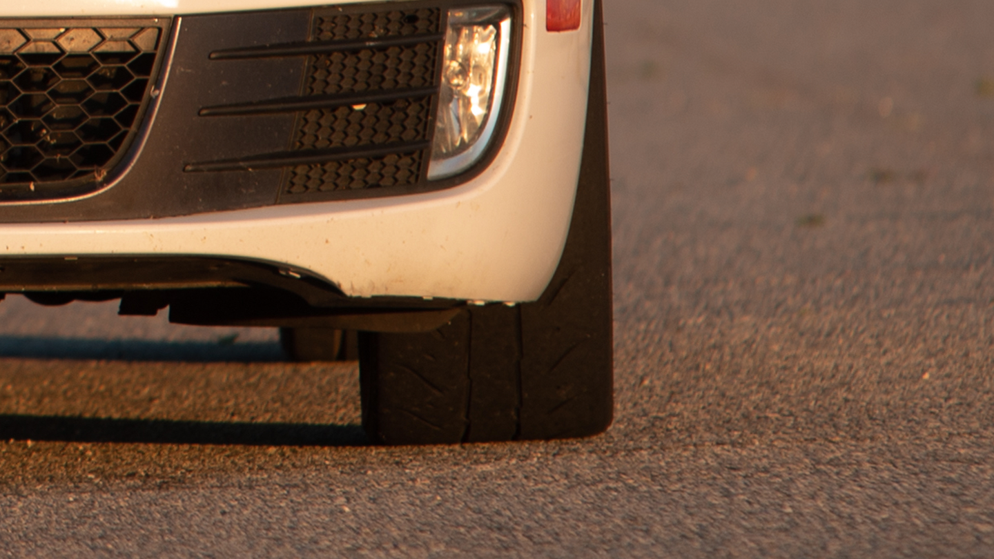A zoomed in image of the front a vehicle, where the image is focused on the driver's side front tire.