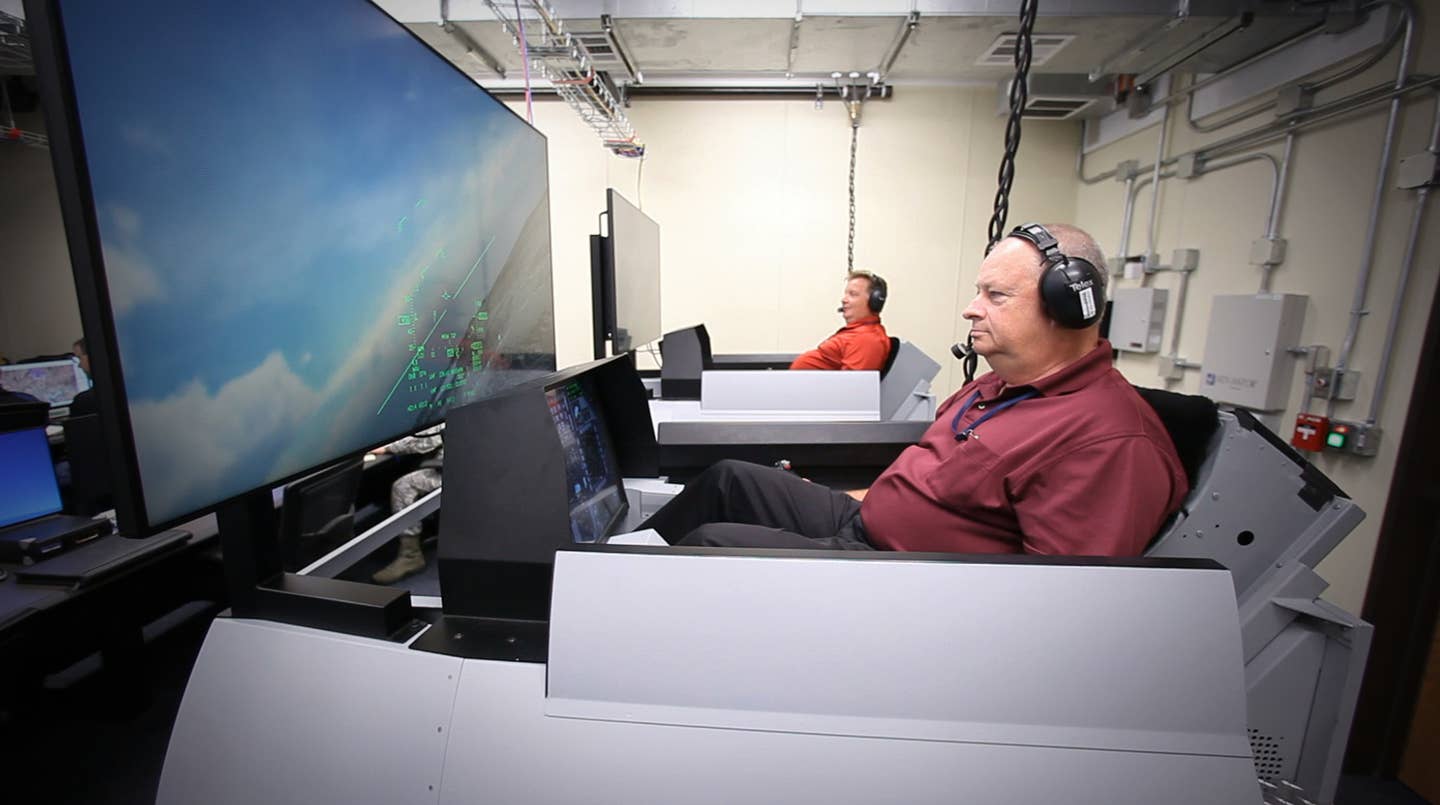 Scott Carpenter and Donald Simones, both subject matter experts in the Air Force Research Laboratory’s 711th Human Performance Wing, fly virtual F-16s in Deployable Tactical Trainers. The live aircraft were able to see and interact with the virtual players during Phase III of the SLATE demonstration at Nellis Air Force Base, Nevada. <em>U.S. Air Force photo/William Graver</em>