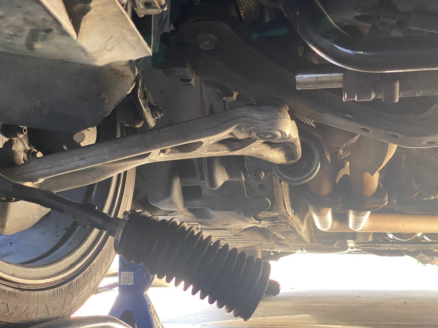 The underside of a BMW E46. The tie rod is hanging down, disconnected from the steering rack.