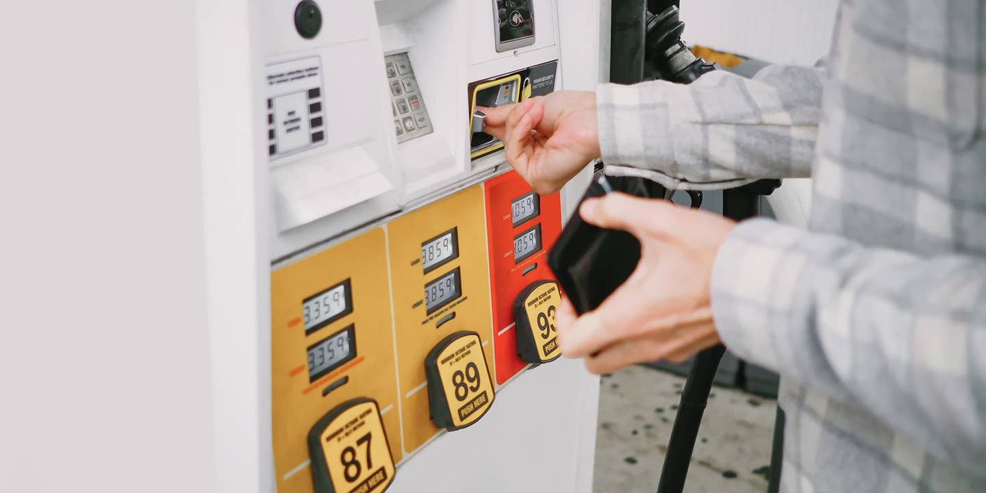 A person using a credit card at the gas pump.