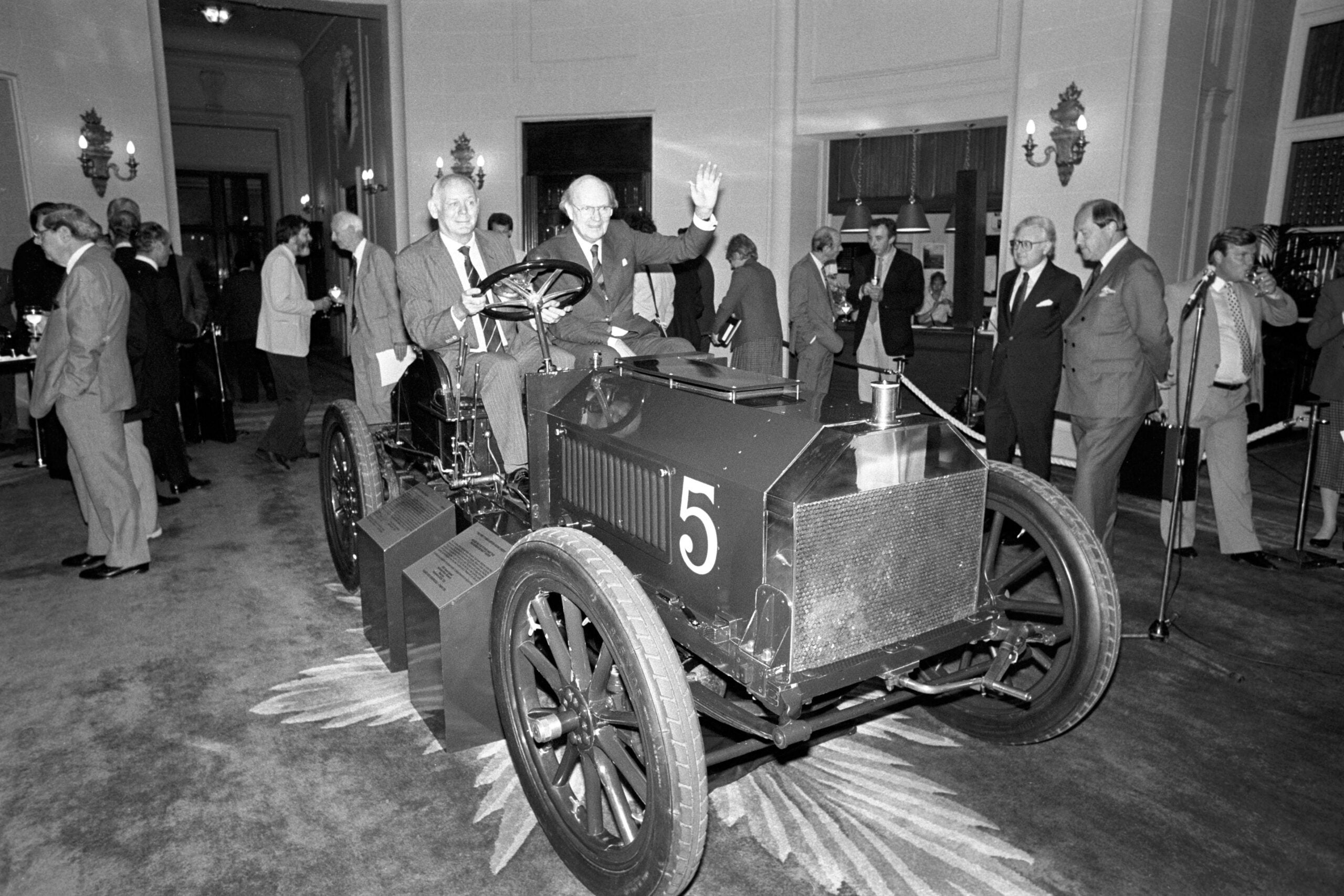 ** Lord Montagu at the wheel of Britain's oldest racing car, the 1903 Gordon Bennett Napier, with Lord Charteris waving from the passenger's seat at the RAC, Pall Mall, London. Lord Montagu, chairman of the National Motor Museum Trust, which bought the car from an American collection.   (Photo by PA Images via Getty Images)