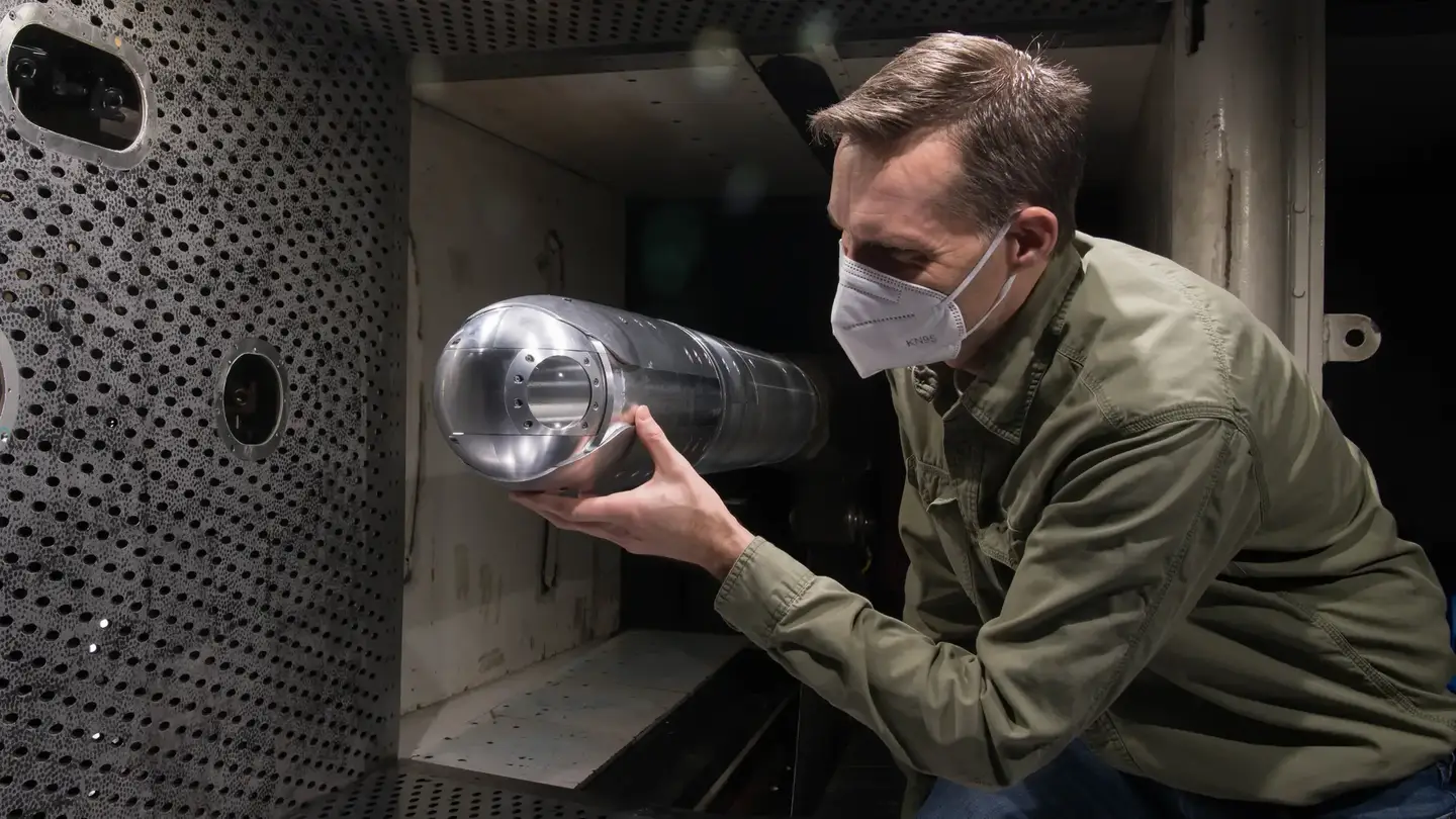 An engineer looks at a directed-energy system turret in the four-foot transonic wind tunnel at Arnold Air Force Base, Tennessee, in March 2021.&nbsp;<em>U.S. Air Force/Jill Pickett</em>