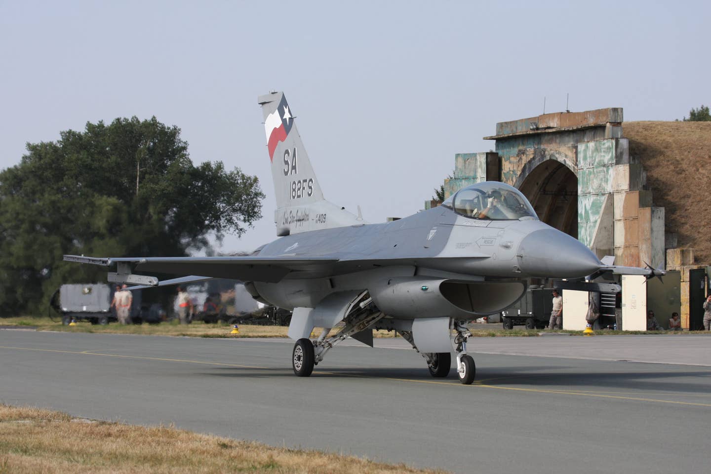 An F-16C from the Texas Air National Guard’s 149th Fighter Wing taxis past a Cold War-era hardened aircraft shelter at Caslav air base after a flight. <em>U.S. Air Force photo by Capt Randy Saldivar</em>