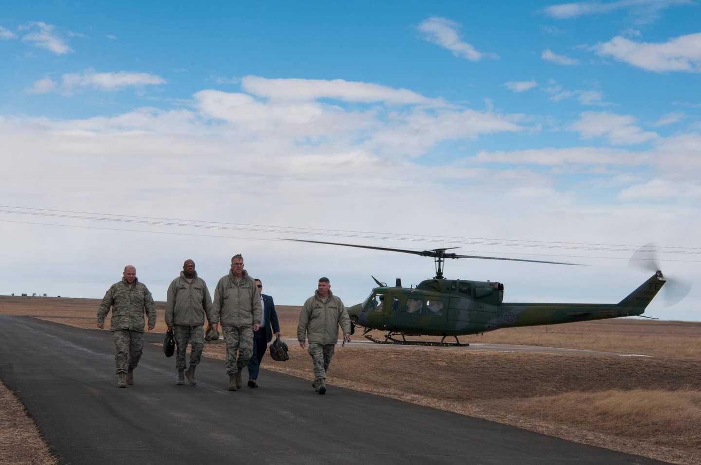 U.S. Air Force Gen. John E. Hyten, the then U.S. Strategic Command commander, and members of his staff depart a 37th Helicopter Squadron UH-1N Huey near a missile alert facility on the F.E. Warren Air Force Base missile complex, in 2017. <em>U.S. Air Force photo by Staff Sgt. Christopher Ruano</em>