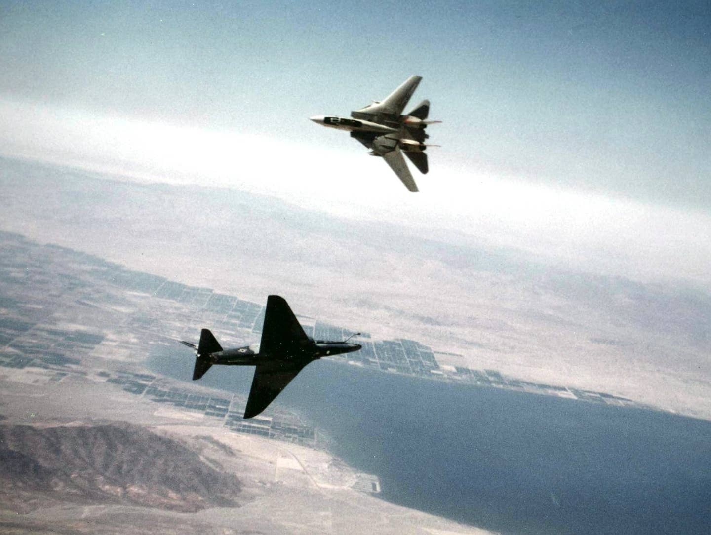 A U.S. Navy A-4F&nbsp;Skyhawk&nbsp;of VF-126 engages an F-14A&nbsp;of VF-111 in air combat maneuvering over the Salton Sea, in 1982. <em>U.S. Navy</em>