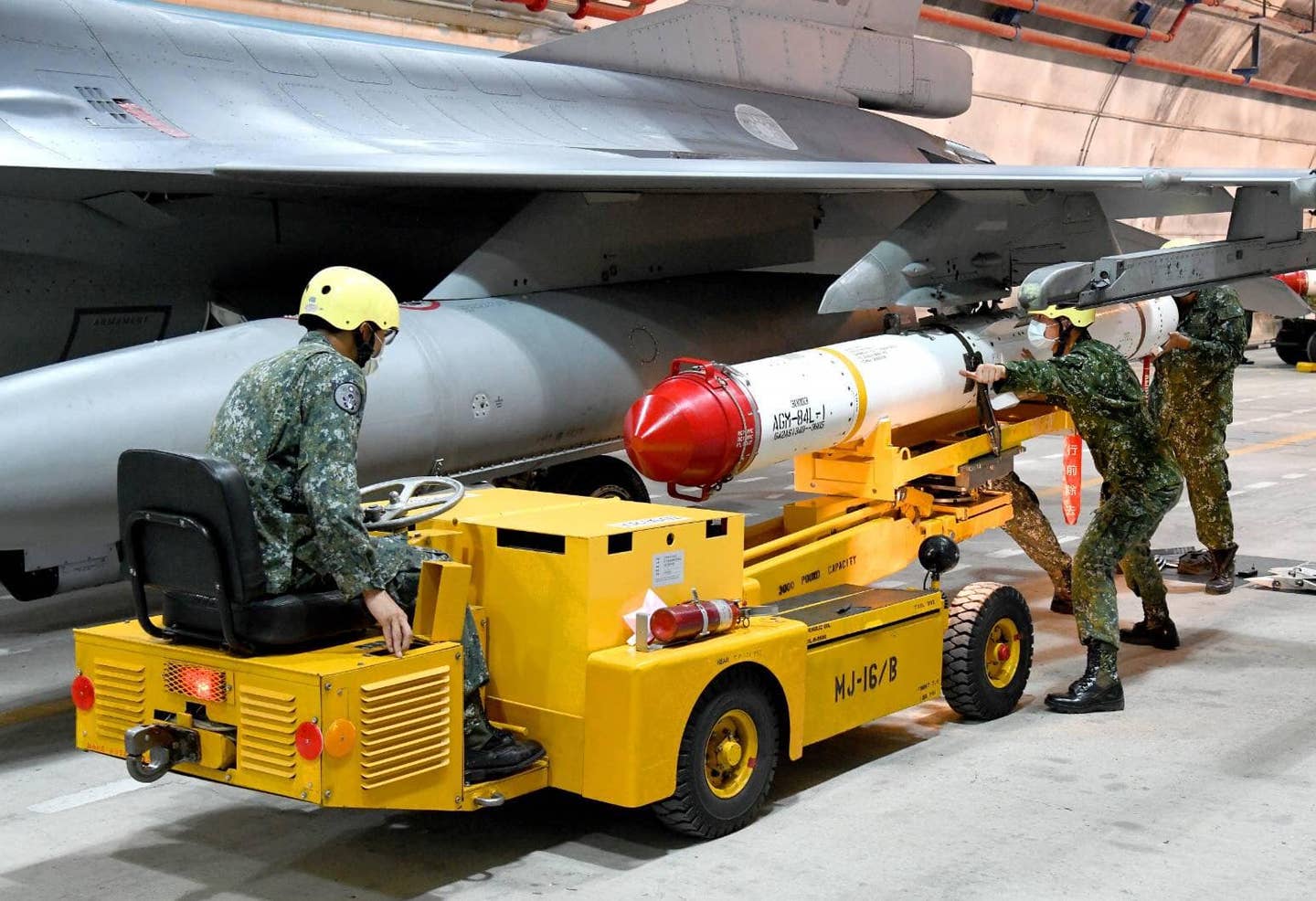 ROCAF crewmembers load a Harpoon anti-ship missile onto an F-16V in Chiashan's underground hangar during a weapons loading exercise. <em>Credit: ROCAF</em>