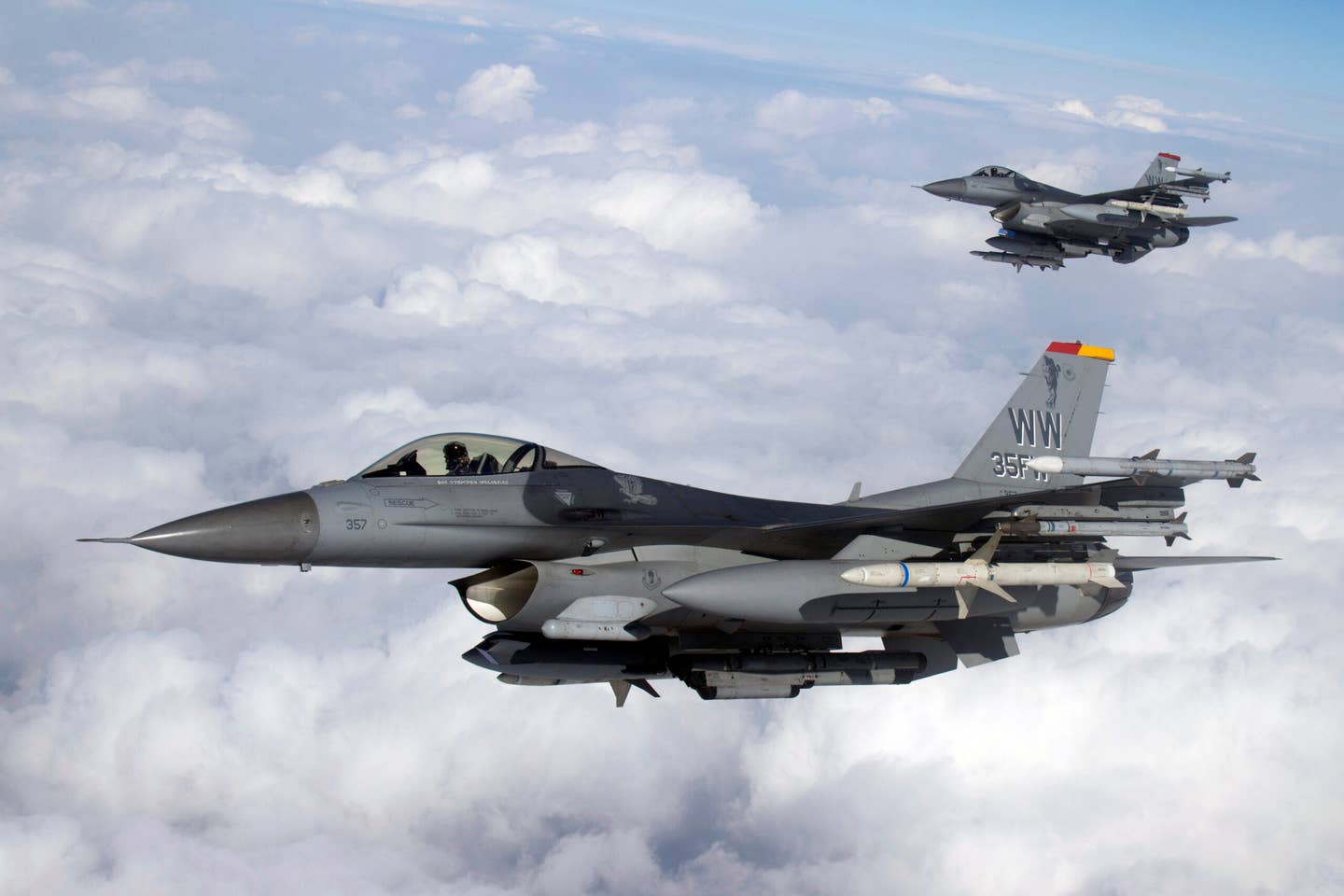 U.S. Air Force F-16C Fighting Falcons with the 35th Fighter Wing fly a training mission over Misawa Air Base, Japan. These Wild Weasels carry inert HARMs and have the HARM Targeting System (HTS) fitted to the engine intake. <em>Photo by Jake Melampy</em>