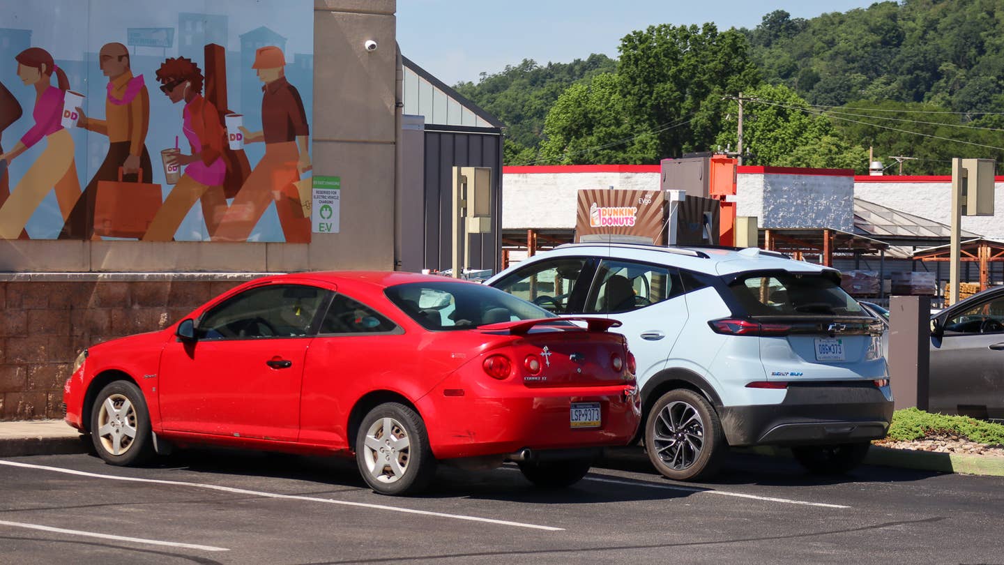 Chevrolet Bolt EUV charging at a Dunkin Donuts in Pittsburgh PA parked next to a Red Chevy Cobalt Coupe