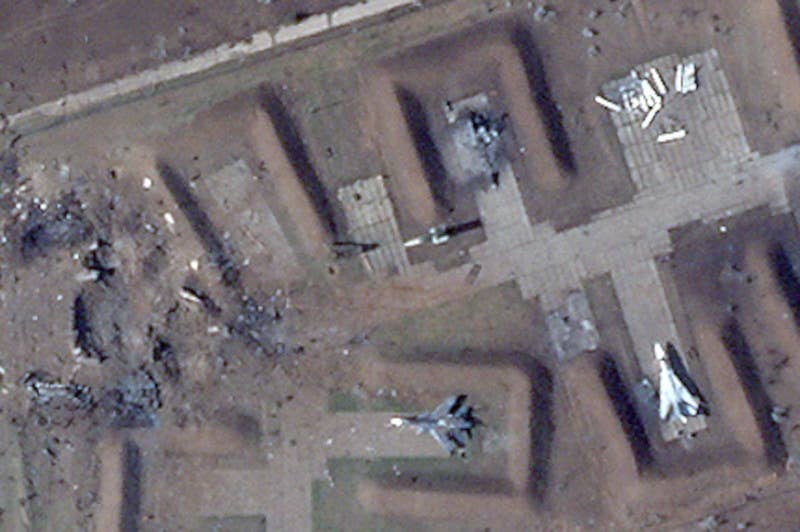 A close-up of the damage to the revetment area. One of the destroyed structures was situated at the bend in the taxiway, where there is now a crater visible in this image, while what's left of the other one, along with a nearby burned-out Su-24, can be seen at the top right corner.&nbsp;<em>PHOTO © 2022 PLANET LABS INC. ALL RIGHTS RESERVED. REPRINTED BY PERMISSION</em>