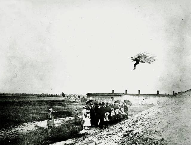 Left side view of Otto Lilienthal in flight in his glider; a small group of spectators watch from below. <em>Credit: Smithsonian Institution/Wikimedia Commons</em>