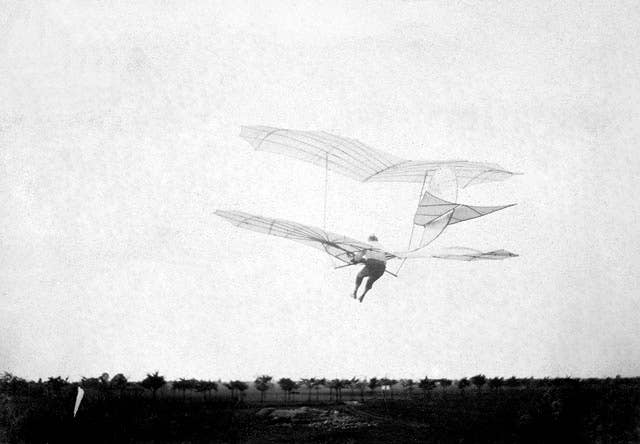 Three-quarter left rear view from below of Otto Lilienthal in flight in his biplane glider. <em>Credit: Smithsonian Institution/Wikimedia Commons</em>