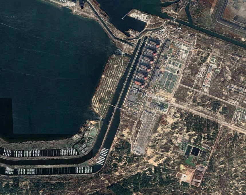 A satellite image offering a more general view of the central portion of the Zaporizhzhia Nuclear Power Plant complex. The six reactor buildings can be clearly seen thanks to their red domes, along with their adjacent turbine halls. <em>Google Earth</em>