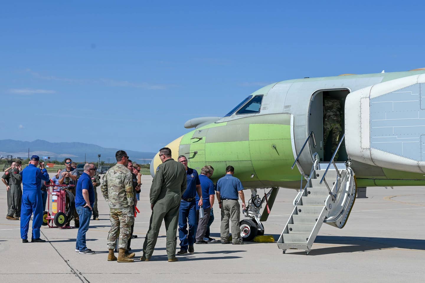 Service members admire an EC-37B Compass Call after its arrival at Davis-Monthan Air Force Base, Arizona, Aug. 17, 2022. The EC-130H Compass Call is scheduled to be replaced by the EC-37B, the first of its kind which has the enhanced flight performance of a commercial business jet airframe. (U.S. Air Force photo by Airman 1st Class)