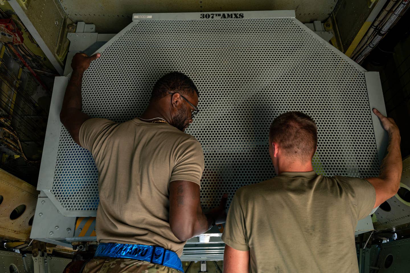 Master Sgt. Anthony Williams Jr., left, 2nd Aircraft Maintenance Squadron production supervisor, and Senior Airman Aaron Wiles, right, 2nd Aircraft Maintenance Squadron engine mechanic, remove the outer wall of an On-board Cargo System inside a B-52H at Fairchild Air Force Base. <em>Credit: Senior Airman Chase Sullivan/U.S. Air Force</em>