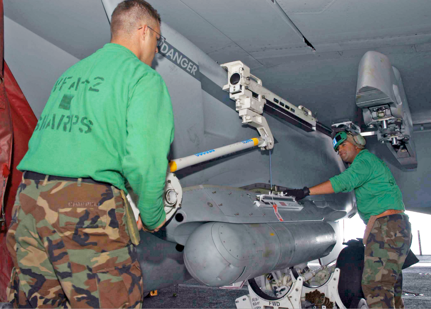 Ground crew load an ATFLIR onto a Super Hornet. <em>(USN)</em>