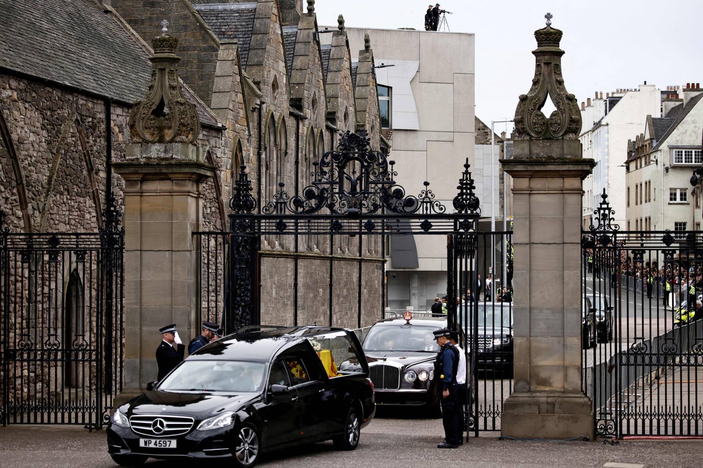 The hearse carrying the coffin of the late Queen Elizabeth II, draped with the Royal Standard of Scotland, arrives at the Palace of Holyroodhouse, in Edinburgh on September 11, 2022. - Queen Elizabeth II's coffin will travel by road through Scottish towns and villages on Sunday as it begins its final journey from her beloved Scottish retreat of Balmoral. The Queen, who died on September 8, will be taken to the Palace of Holyroodhouse before lying at rest in St Giles' Cathedral, before travelling onwards to London for her funeral.. (Photo by ALKIS KONSTANTINIDIS / POOL / AFP) (Photo by ALKIS KONSTANTINIDIS/POOL/AFP via Getty Images)