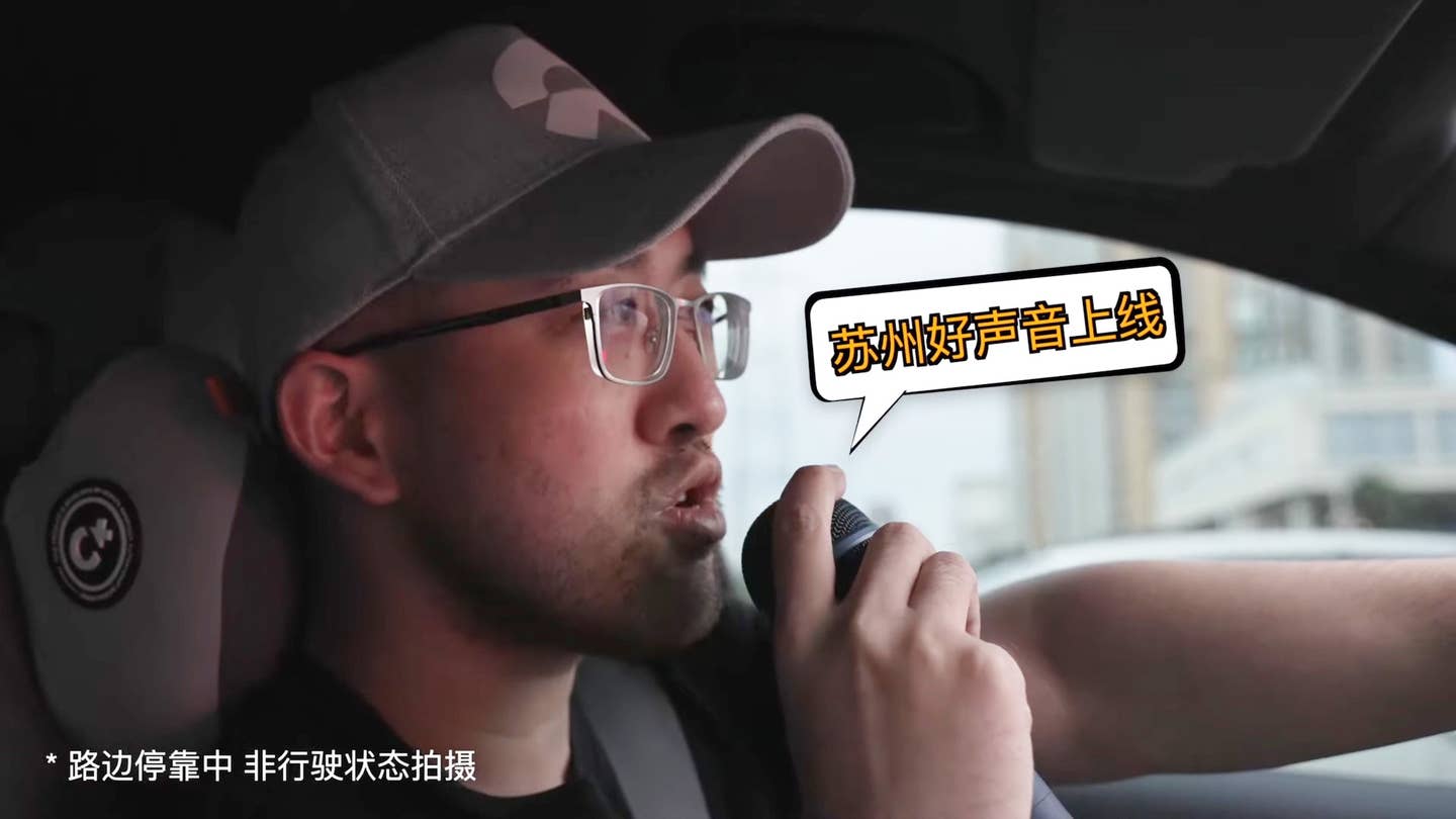 A Chinese car reviewer sings into the microphone of a Nio