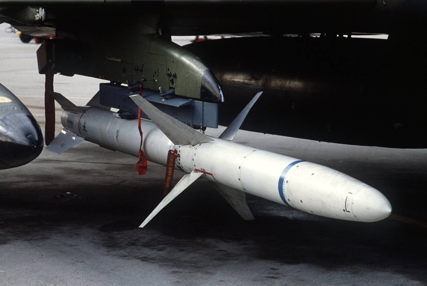 A view of an AGM-88 HARM high-speed anti-radiation missile mounted beneath the wing of a 37th Tactical Fighter Wing F-4G Phantom II "Wild Weasel" aircraft. <em>Credit: Ssgt. Scott Stewart/Wikimedia Commons</em>