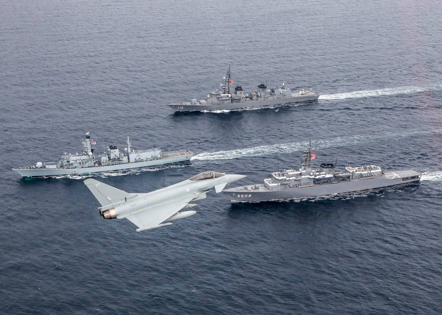 A Typhoon FGR4 from RAF Coningsby flies over a pair of Japan Maritime Self-Defense Force warships accompanied by the Type 23 frigate HMS <em>Northumberland</em> in the North Sea in 2018. <em>Crown Copyright</em>