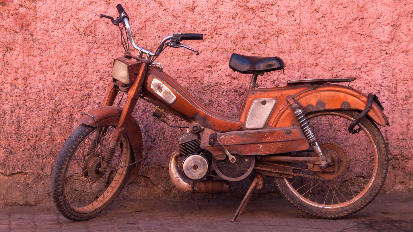 A moped against a wall.