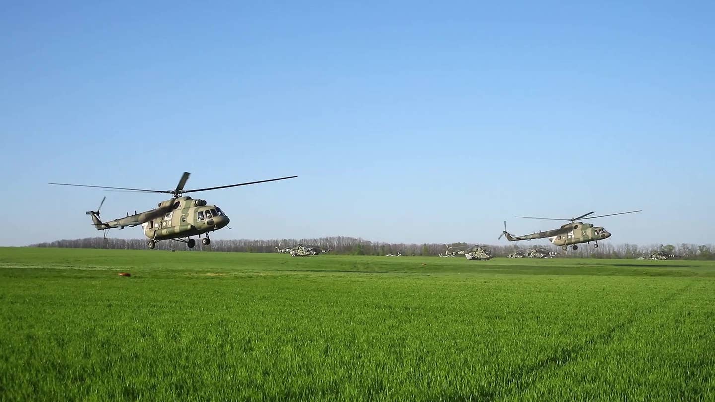 A pair of Mi-8MTPR-1 helicopters prepare for a mission over Ukraine, with various other Mi-8s in the background. <em>Russian Ministry of Defense</em>