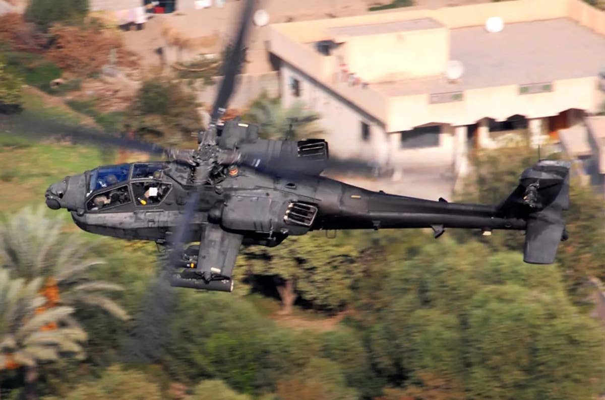 A picture of a US Army AH-64 offering a good look at the current standard upswept engine exhaust configuration. <em>US Army</em>