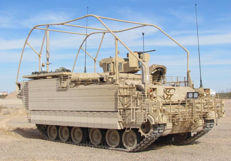 A standard AMPV APC variant with slat armor and ERA tiles, along with a large tubular frame on top to deflect wires and any similar hazards. <em>BAE Systems</em>